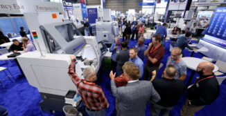 Manufacturing operations leader speaking with an ERP software vendor at a trade show booth at IMTS 2026 in Chicago