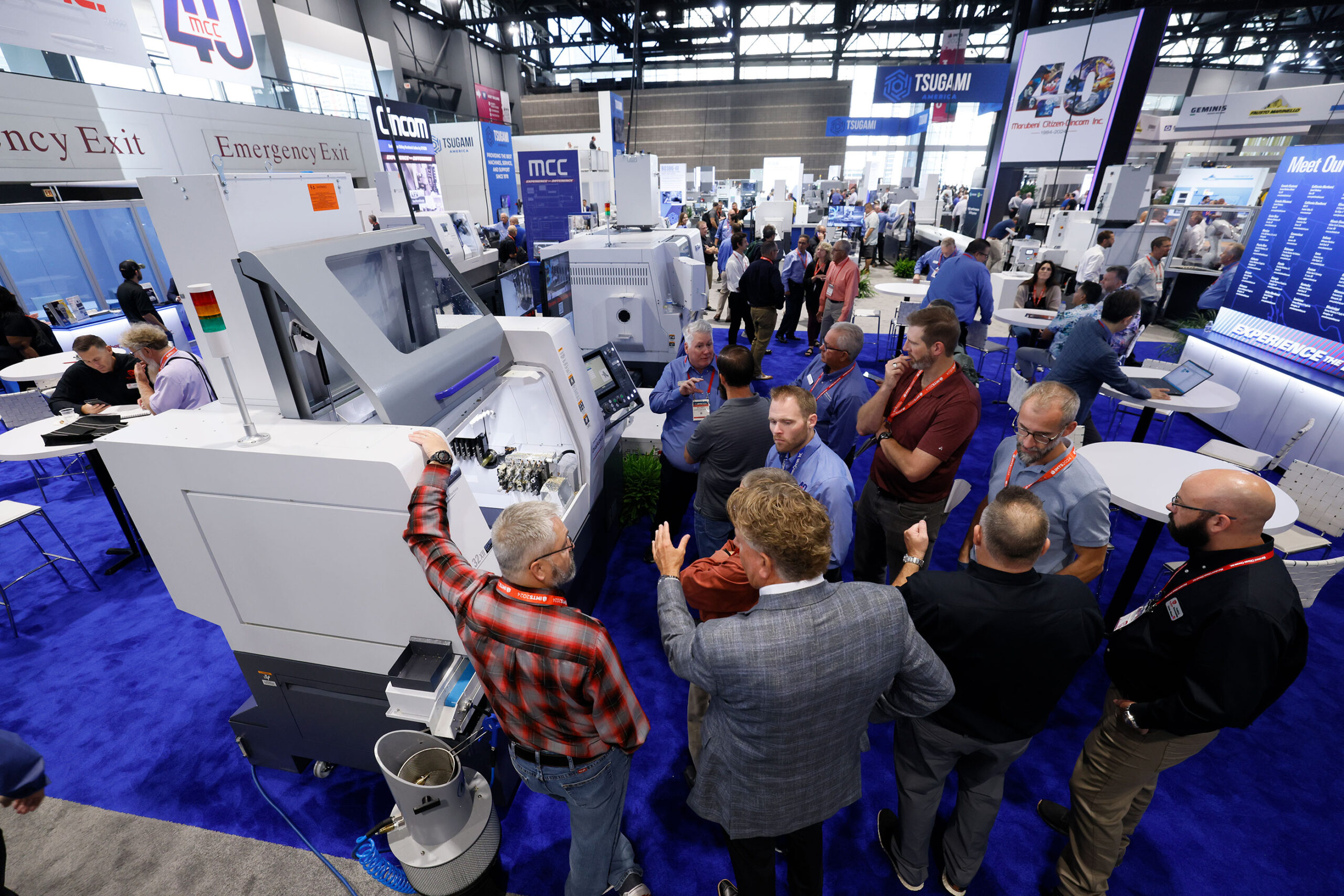 Manufacturing operations leader speaking with an ERP software vendor at a trade show booth at IMTS 2026 in Chicago